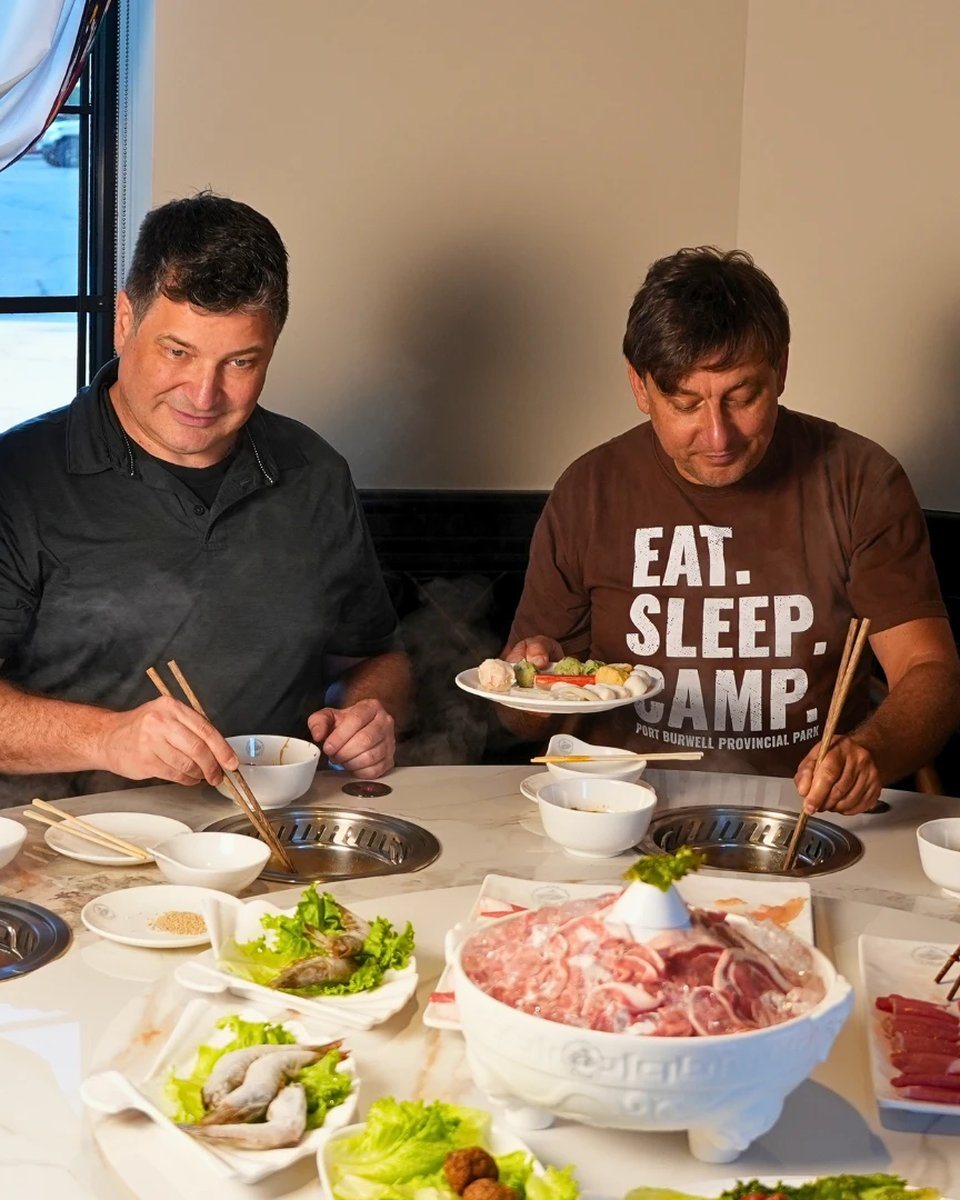 A group sharing a loaded hot pot table at Otluk Hot Pot