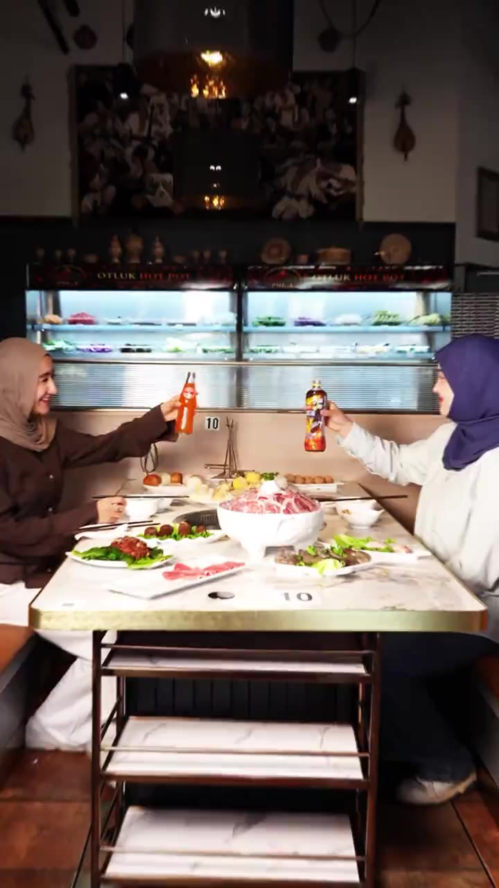 Two guests raising drinks over the pot